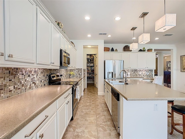 kitchen featuring a center island with sink, visible vents, appliances with stainless steel finishes, and a sink