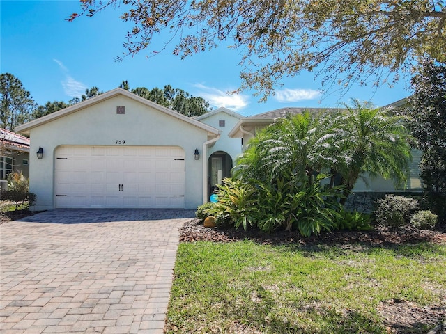 view of front of house featuring stucco siding, decorative driveway, and an attached garage