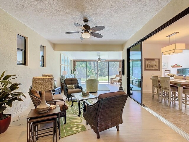 living room with a textured ceiling, wood finished floors, and a textured wall