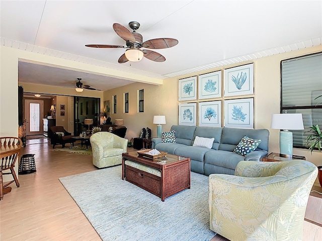 living room with light wood-type flooring, beam ceiling, and a ceiling fan