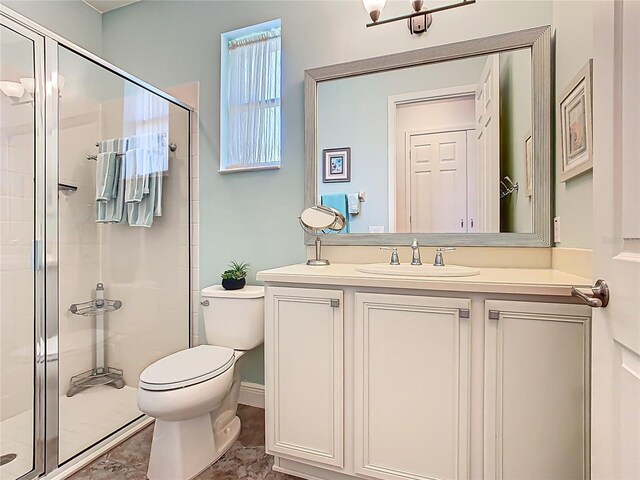 bathroom featuring toilet, a stall shower, and vanity