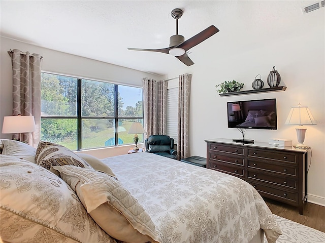 bedroom featuring visible vents, baseboards, dark wood-type flooring, and ceiling fan