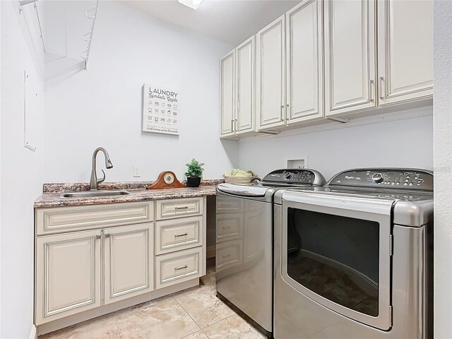 clothes washing area with washer and clothes dryer, cabinet space, and a sink