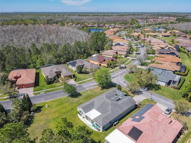 aerial view with a residential view, a wooded view, and a water view