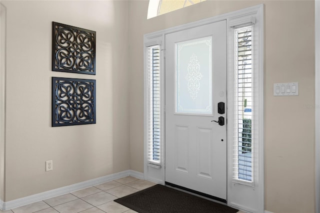 foyer entrance featuring light tile patterned floors and baseboards