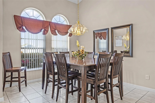 tiled dining room with a healthy amount of sunlight, baseboards, and an inviting chandelier