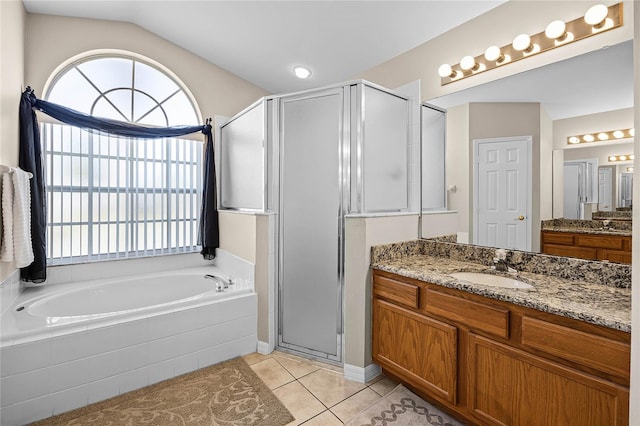 full bath featuring vanity, a garden tub, a stall shower, vaulted ceiling, and tile patterned floors