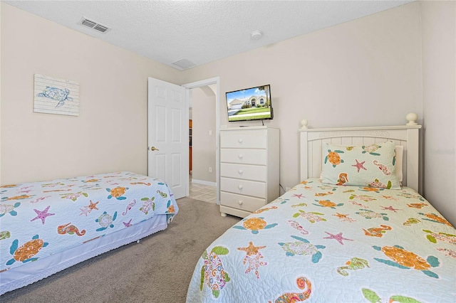 bedroom featuring carpet flooring, visible vents, and a textured ceiling