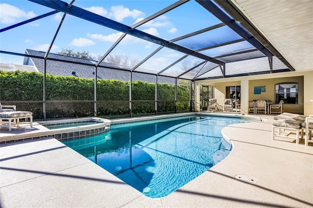 view of swimming pool featuring a patio area, glass enclosure, and a pool with connected hot tub