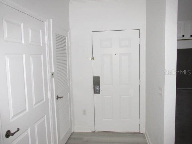 doorway to outside with light wood-type flooring and baseboards