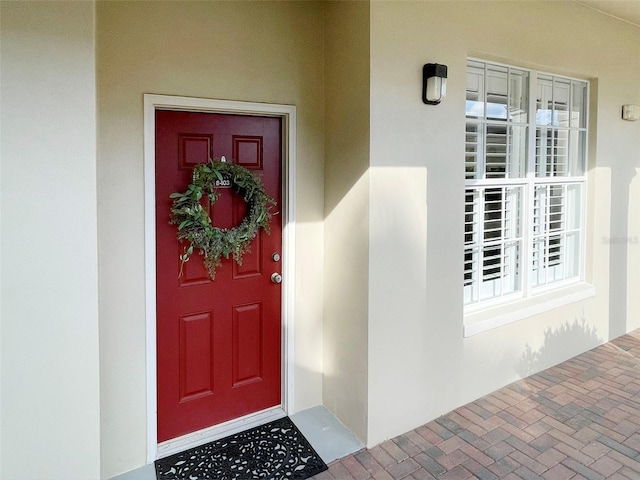 view of exterior entry featuring stucco siding