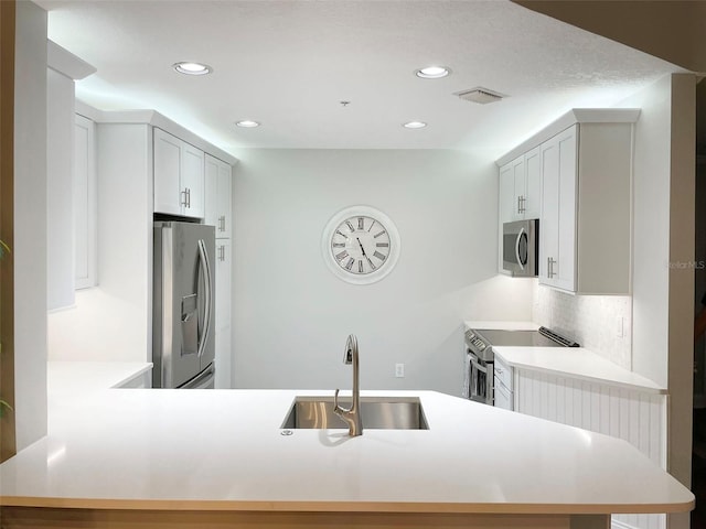 kitchen featuring decorative backsplash, appliances with stainless steel finishes, light countertops, and a sink