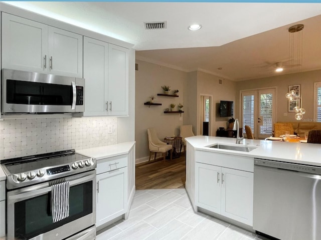 kitchen featuring visible vents, a sink, light countertops, appliances with stainless steel finishes, and backsplash