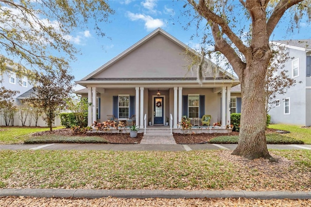 view of front of property featuring stucco siding, a porch, a front lawn, and fence