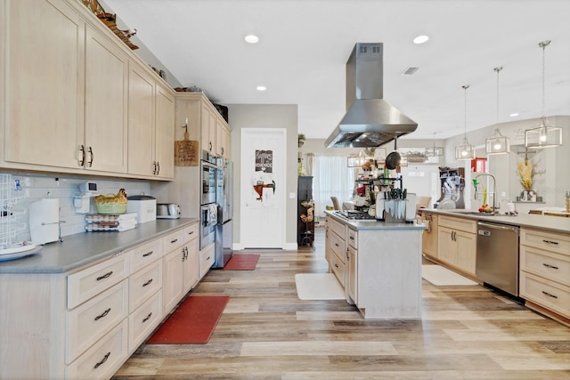 kitchen with island exhaust hood, light wood-type flooring, appliances with stainless steel finishes, and a center island