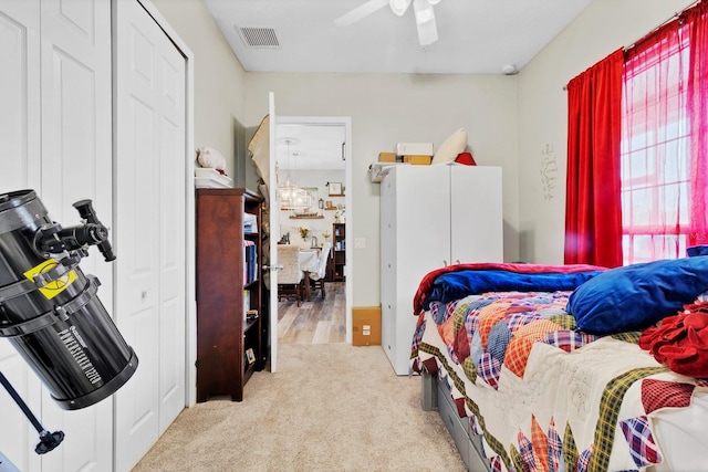 carpeted bedroom with visible vents and a ceiling fan