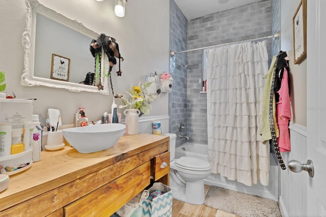 bathroom with vanity, shower / bath combination with curtain, toilet, and wood finished floors