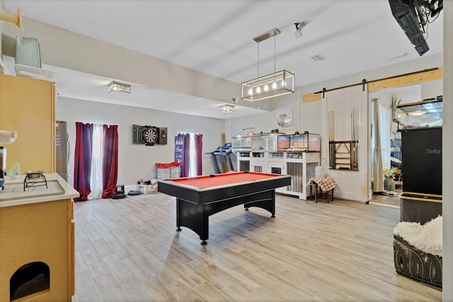 rec room with a barn door, visible vents, light wood-style flooring, and pool table