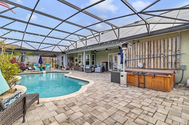 outdoor pool featuring a patio, ceiling fan, a hot tub, outdoor lounge area, and a lanai