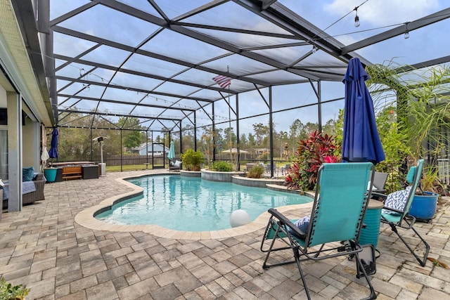 outdoor pool with glass enclosure, a hot tub, and a patio