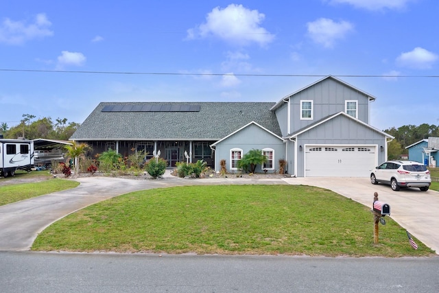 traditional-style home with driveway, board and batten siding, solar panels, and a front yard