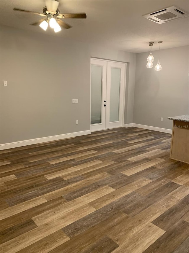 empty room featuring visible vents, dark wood-type flooring, a ceiling fan, french doors, and baseboards