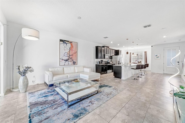 living room with recessed lighting, light tile patterned floors, baseboards, and visible vents