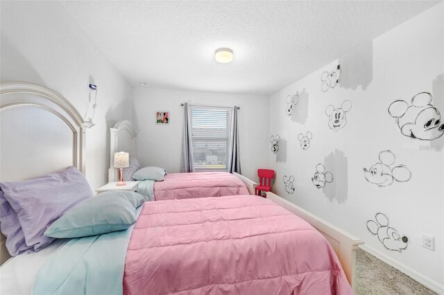 bedroom with baseboards, carpet floors, and a textured ceiling