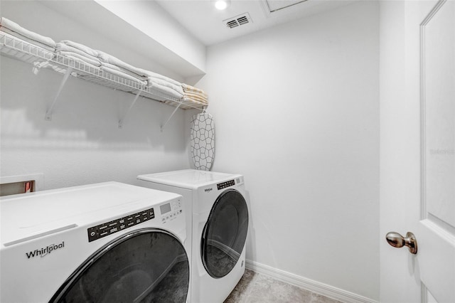 clothes washing area with visible vents, baseboards, separate washer and dryer, and laundry area