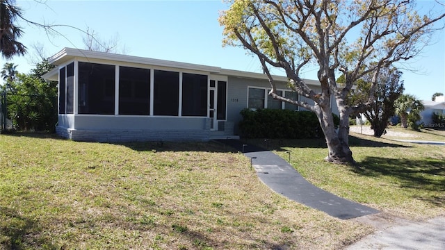 view of front of property featuring a front yard and a sunroom