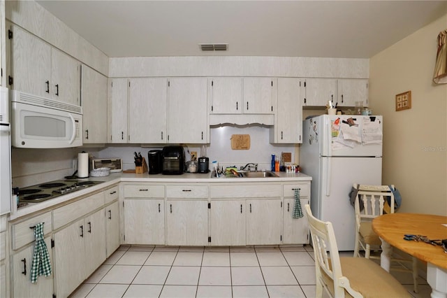 kitchen with visible vents, light countertops, light tile patterned floors, white appliances, and a sink