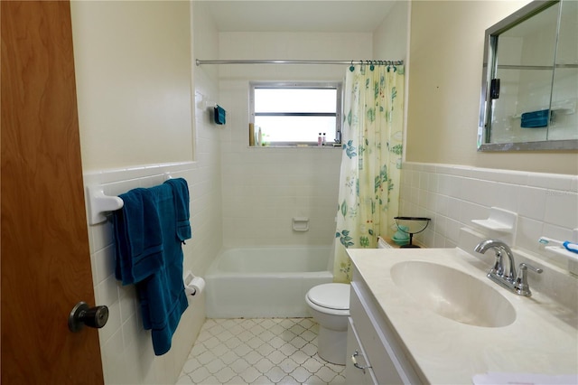 bathroom featuring toilet, tile walls, wainscoting, shower / bath combination with curtain, and vanity