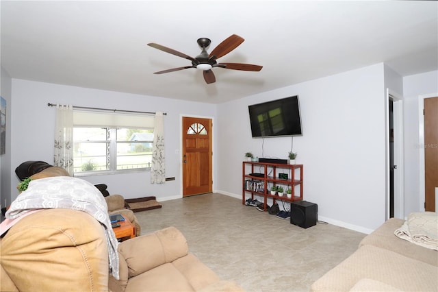 living area with ceiling fan and baseboards