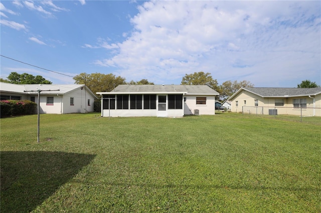 back of property with a yard and a sunroom