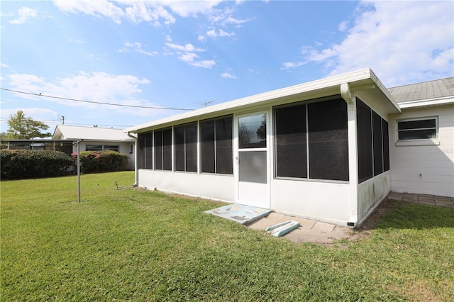 back of house with a yard and a sunroom