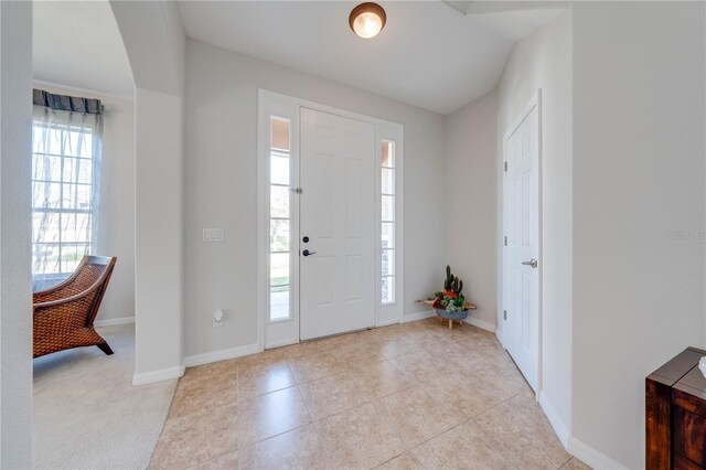 foyer entrance featuring light tile patterned floors and baseboards