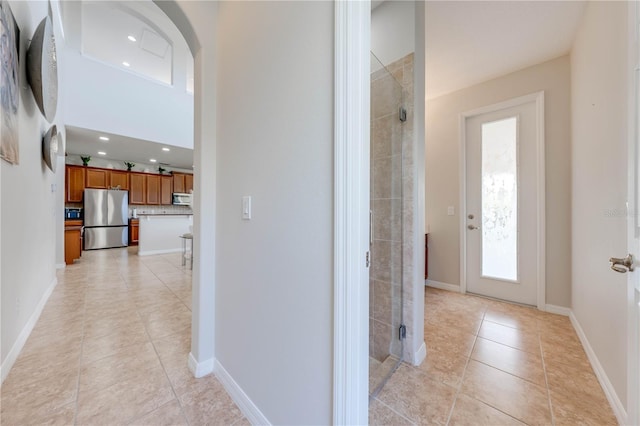 corridor with light tile patterned floors, recessed lighting, and baseboards