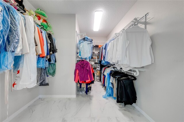 walk in closet with marble finish floor