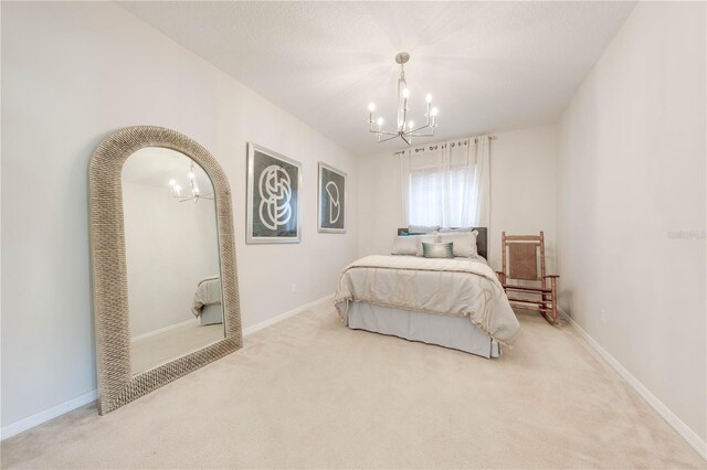 bedroom with a notable chandelier, carpet, and baseboards