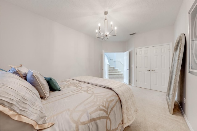 bedroom featuring baseboards, visible vents, a closet, light colored carpet, and a chandelier