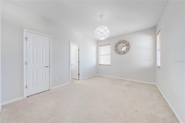 carpeted empty room featuring baseboards