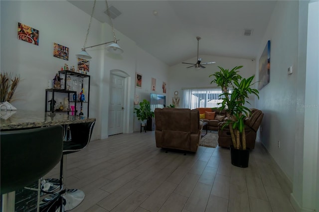 living area featuring light wood-type flooring, visible vents, high vaulted ceiling, and a ceiling fan