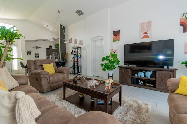 living room featuring ceiling fan, visible vents, and high vaulted ceiling