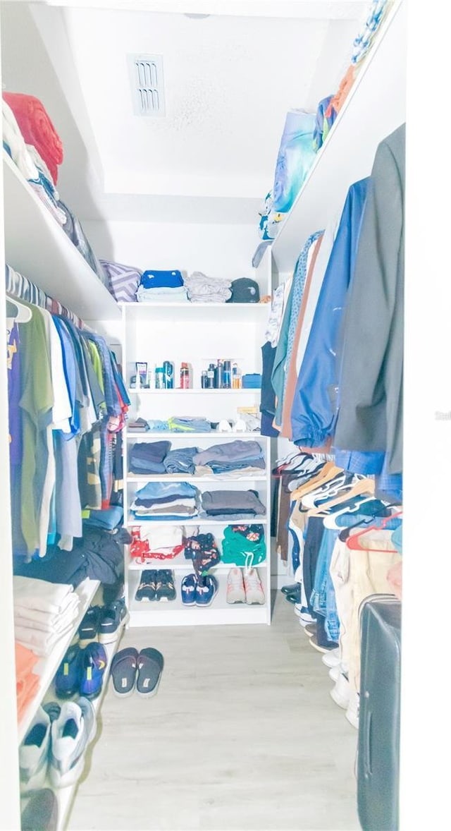 spacious closet featuring wood finished floors and visible vents