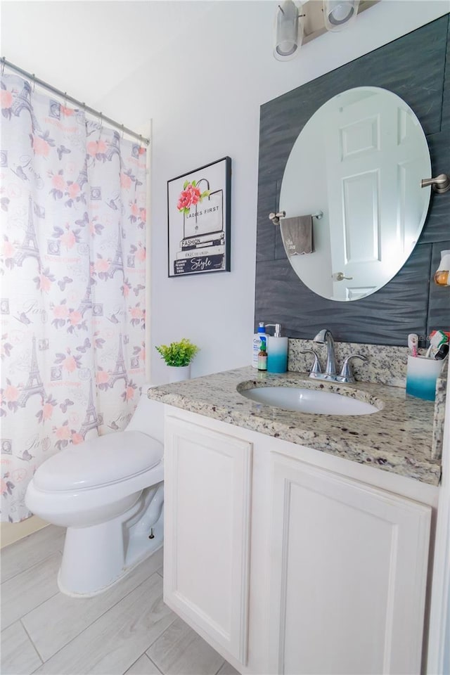 full bath featuring a shower with curtain, toilet, and vanity