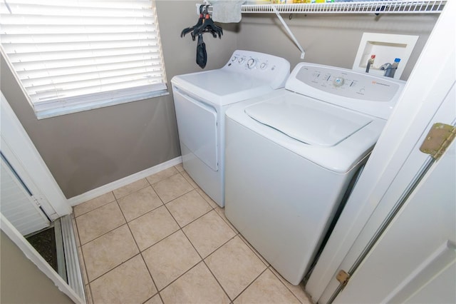 laundry room featuring washer and dryer, laundry area, light tile patterned floors, and baseboards