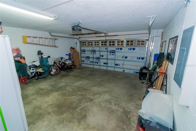 garage featuring freestanding refrigerator and a garage door opener