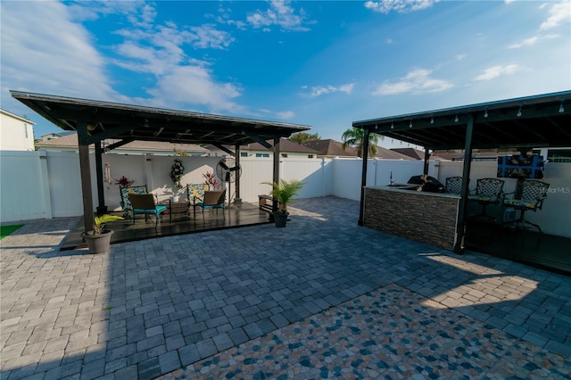 view of patio featuring a gazebo, a fenced backyard, and exterior kitchen