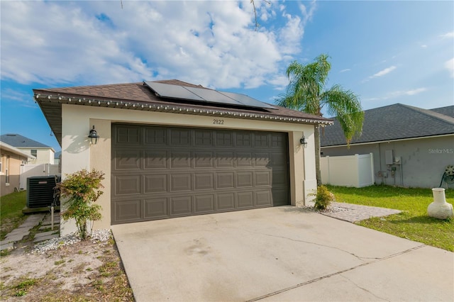 view of front of home with roof mounted solar panels, cooling unit, and fence