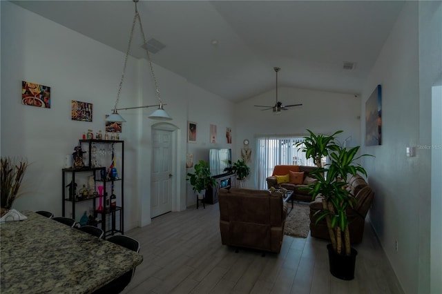 living room featuring light wood finished floors, visible vents, high vaulted ceiling, and a ceiling fan